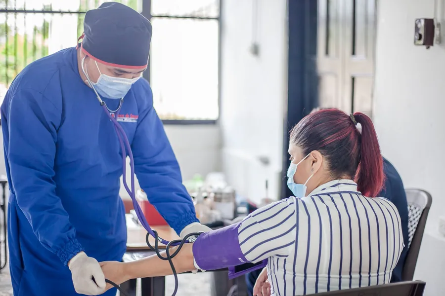 Nhân viên y tế đo huyết áp cho người đến khám